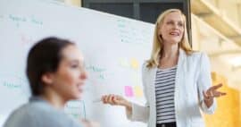 Mitarbeitende steht vor Whiteboard und erklärt